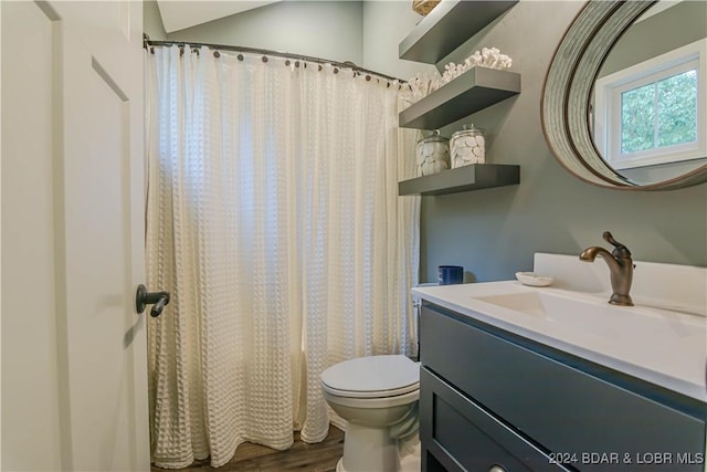 bathroom featuring lofted ceiling, toilet, vanity, a shower with shower curtain, and hardwood / wood-style flooring