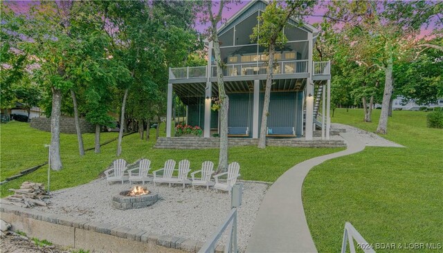 view of yard with a patio, a balcony, and an outdoor fire pit