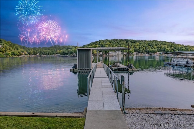 view of dock featuring a water view and a forest view