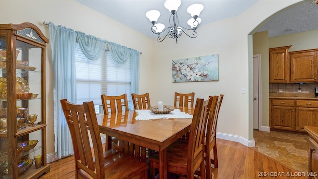 dining area with light wood-type flooring and a chandelier