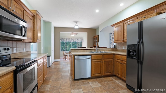 kitchen with stainless steel appliances, sink, backsplash, and kitchen peninsula