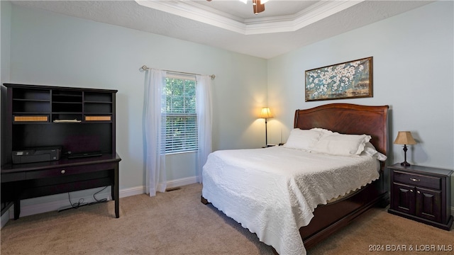 bedroom with ornamental molding, light carpet, ceiling fan, and a raised ceiling