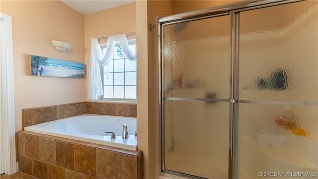 bathroom featuring shower with separate bathtub