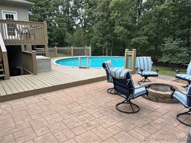 view of pool with a deck and a fire pit