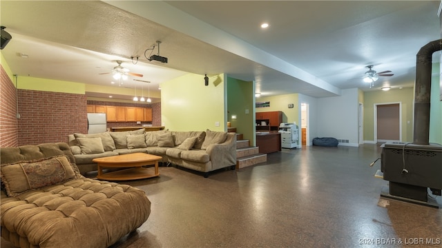 living room with a wood stove and ceiling fan