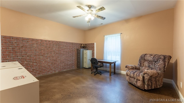 living area with brick wall and ceiling fan