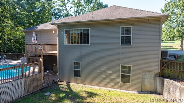 back of property featuring central AC unit and a swimming pool side deck