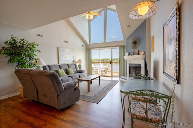 living room featuring high vaulted ceiling, a water view, ceiling fan, and dark hardwood / wood-style floors