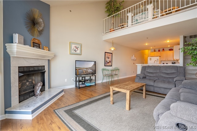 living room with hardwood / wood-style floors, high vaulted ceiling, and a fireplace