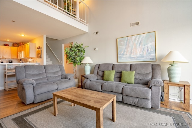 living room with light hardwood / wood-style flooring and a high ceiling