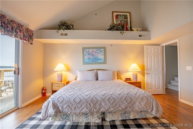 bedroom featuring light wood-type flooring, vaulted ceiling, and access to outside