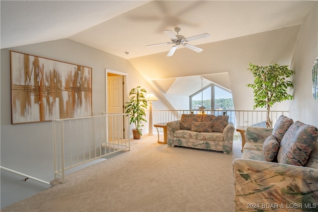 carpeted living room with ceiling fan and vaulted ceiling