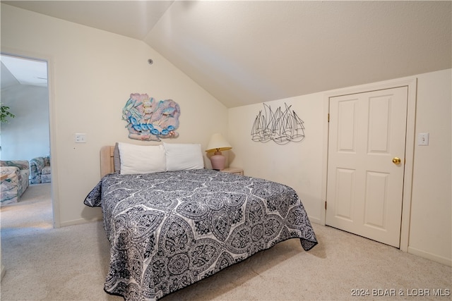 bedroom with vaulted ceiling and light colored carpet