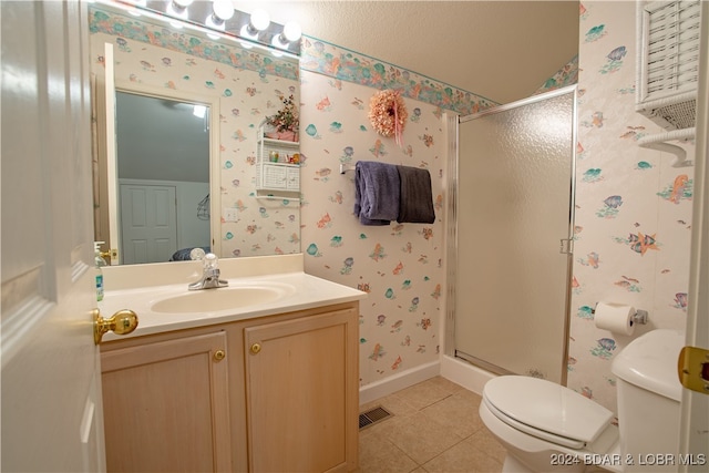 bathroom featuring tile patterned flooring, a shower with shower door, toilet, and vanity