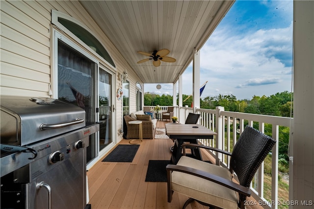 wooden terrace featuring ceiling fan and grilling area