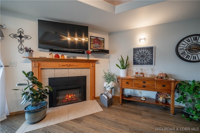 living room featuring hardwood / wood-style flooring, a fireplace, and a textured ceiling