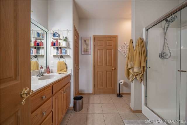 bathroom featuring a shower with shower door, vanity, and tile patterned floors