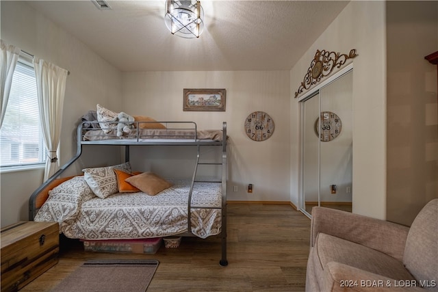 bedroom featuring a textured ceiling, a closet, and wood-type flooring