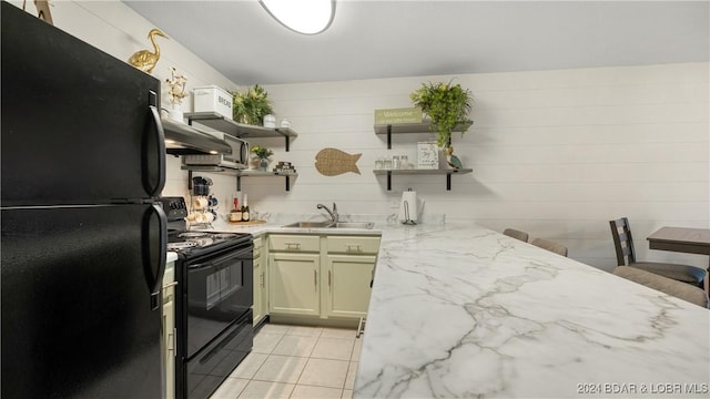 kitchen with sink, light tile patterned floors, black appliances, and light stone countertops