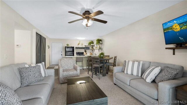 carpeted living room featuring ceiling fan