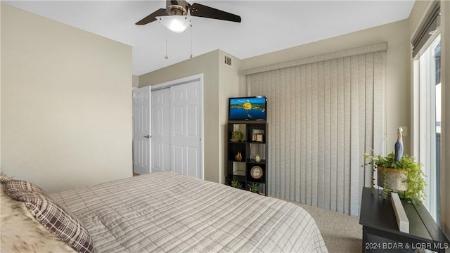 carpeted bedroom featuring ceiling fan and a closet