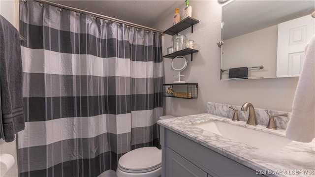 bathroom featuring a shower with curtain, vanity, and toilet