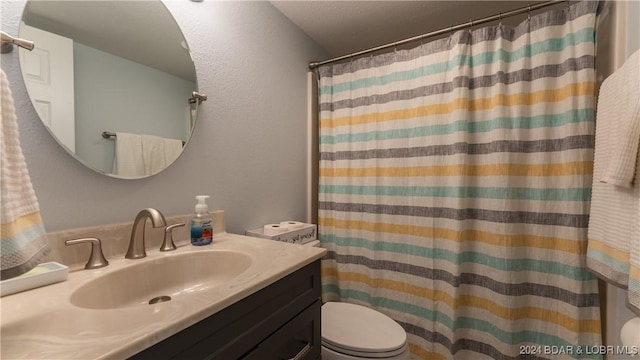 bathroom featuring vanity, a shower with shower curtain, and toilet