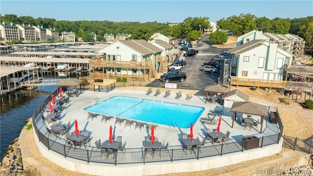 view of swimming pool featuring a water view and a patio