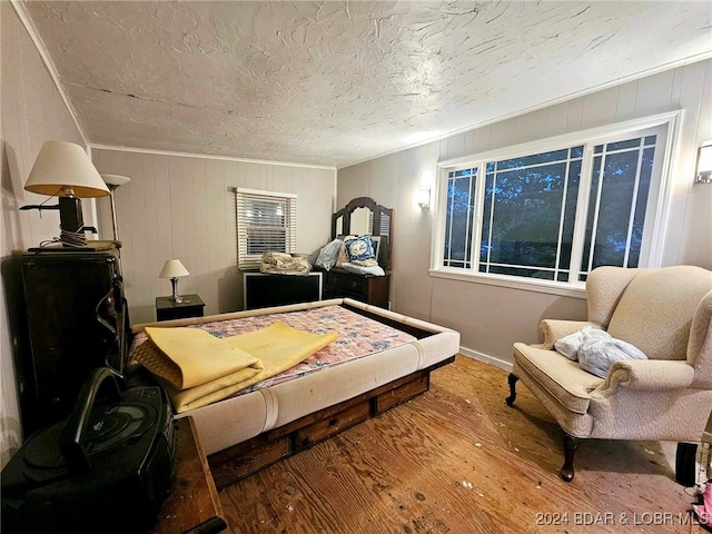 bedroom with crown molding and hardwood / wood-style floors