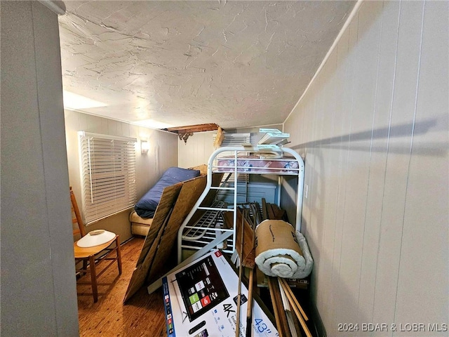 bedroom featuring hardwood / wood-style floors and wood walls