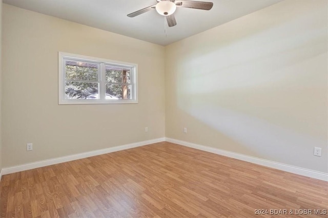 empty room with light wood-style flooring, baseboards, and a ceiling fan