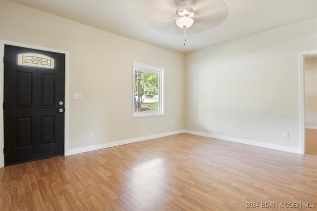 foyer with light wood finished floors, a ceiling fan, and baseboards