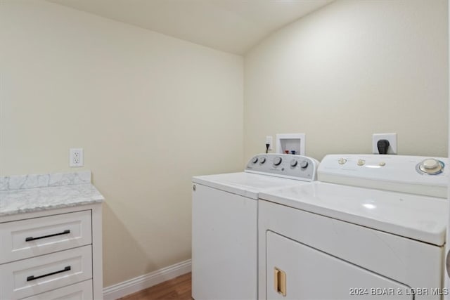 washroom with hardwood / wood-style flooring, independent washer and dryer, and cabinets