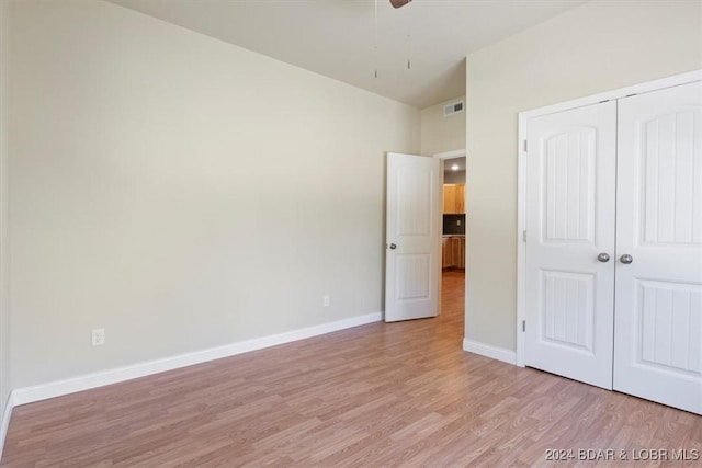 unfurnished bedroom with visible vents, light wood-type flooring, a closet, baseboards, and ceiling fan