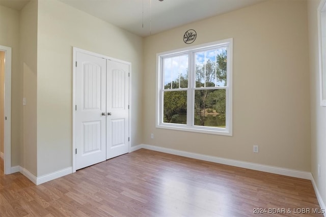 unfurnished bedroom featuring a closet and light wood-type flooring