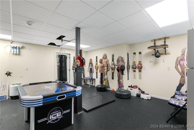 interior space with baseboards and a paneled ceiling