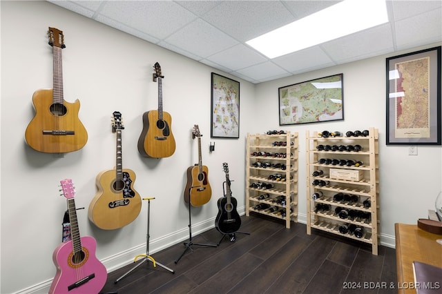 workout area with a drop ceiling and dark hardwood / wood-style floors