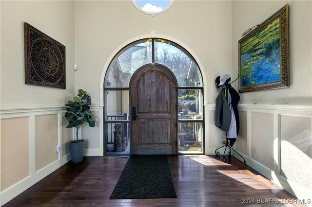 entrance foyer with a decorative wall, wood-type flooring, and a wainscoted wall