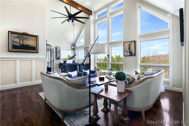 living room featuring plenty of natural light, dark hardwood / wood-style floors, beam ceiling, and ceiling fan