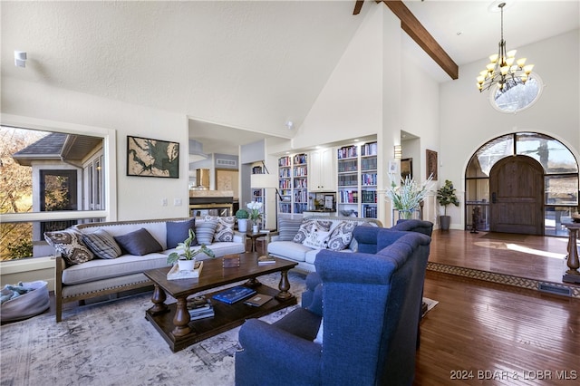 living room with hardwood / wood-style flooring, a fireplace, a notable chandelier, high vaulted ceiling, and a textured ceiling