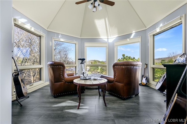 sunroom / solarium with lofted ceiling, ceiling fan, and plenty of natural light