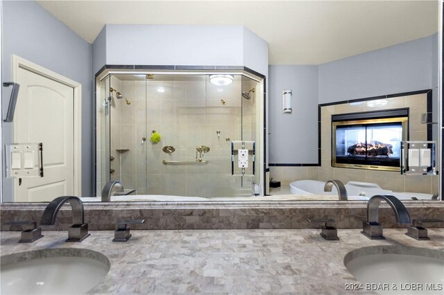 bathroom with double vanity, a sink, and a stall shower