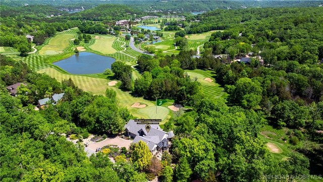 bird's eye view with a forest view, view of golf course, and a water view