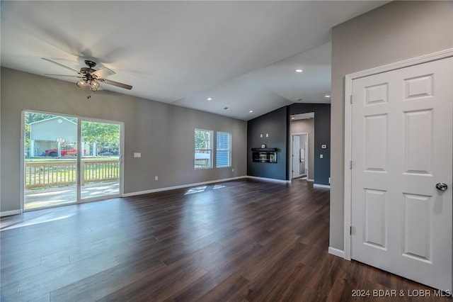 unfurnished living room with ceiling fan, plenty of natural light, dark wood-type flooring, and vaulted ceiling