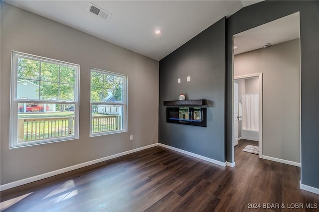 unfurnished room with dark wood-type flooring and vaulted ceiling