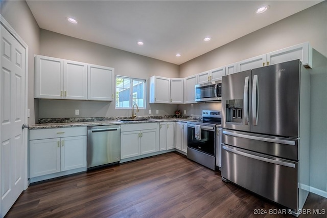 kitchen featuring dark hardwood / wood-style flooring, stainless steel appliances, sink, stone counters, and white cabinets