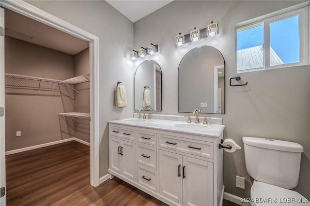 bathroom with toilet, vanity, and hardwood / wood-style flooring