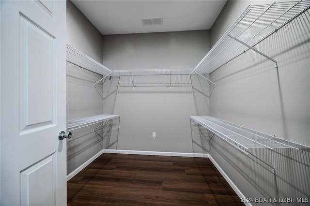 spacious closet with dark hardwood / wood-style flooring