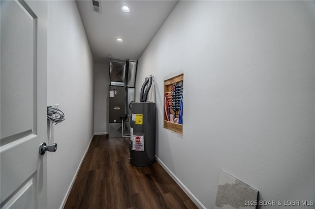 corridor featuring heating unit, water heater, and dark hardwood / wood-style floors