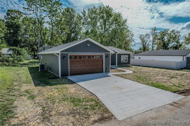 view of front of property featuring a front lawn, central AC unit, and a garage